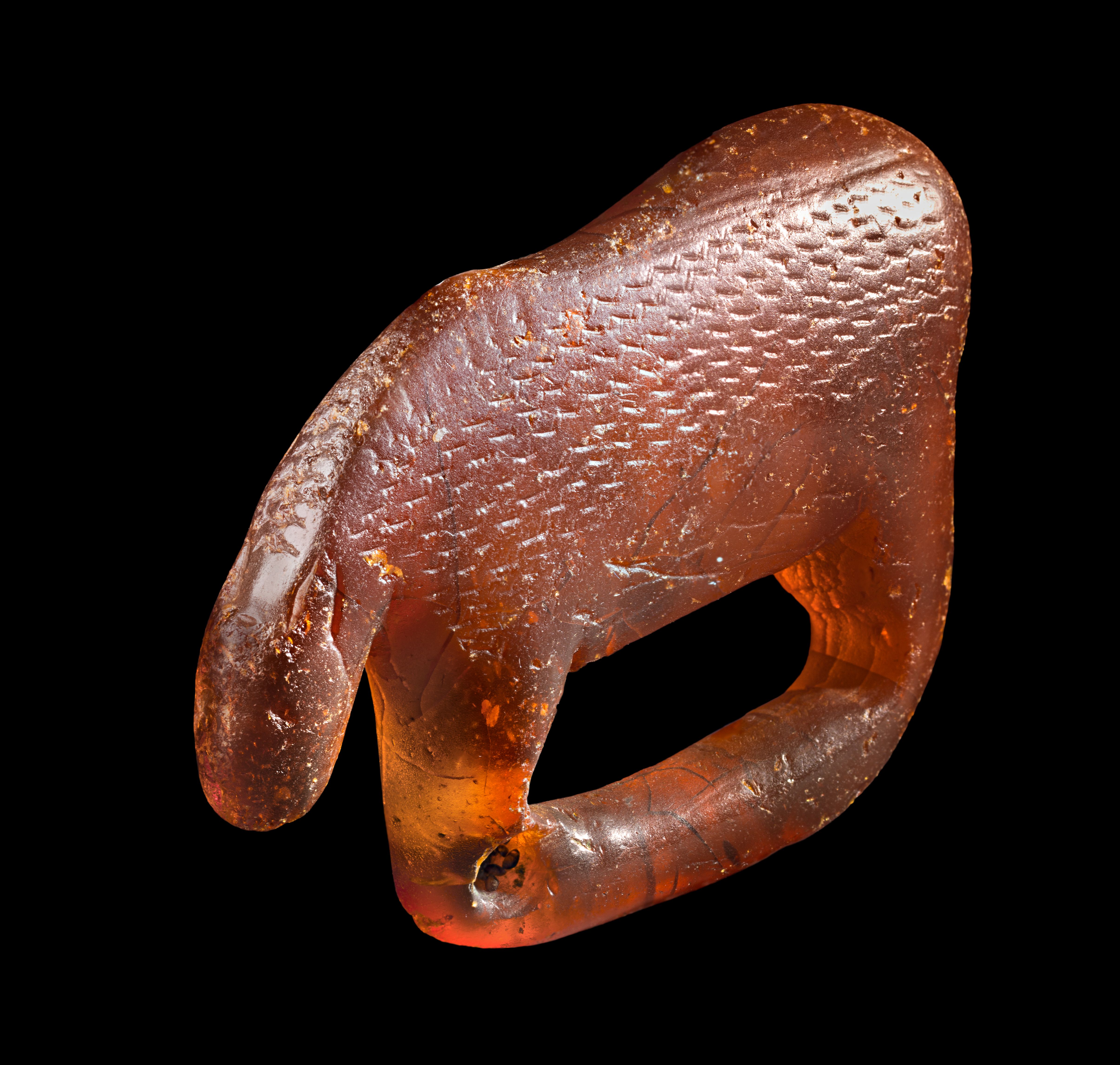 Small animal figurine carved from translucent golden-brown Baltic amber