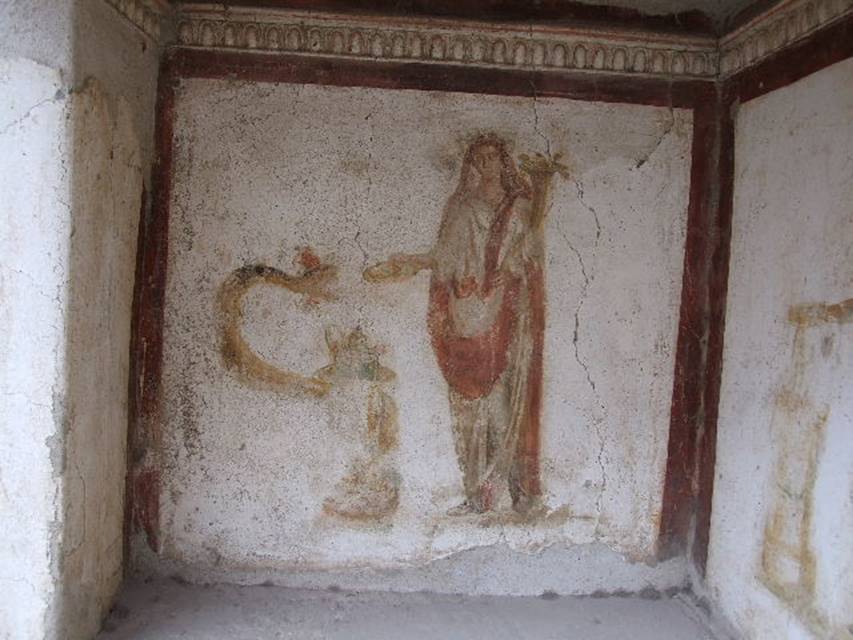 Ancient Roman fresco showing a robed figure (genius) beside a serpent coiled around a round altar