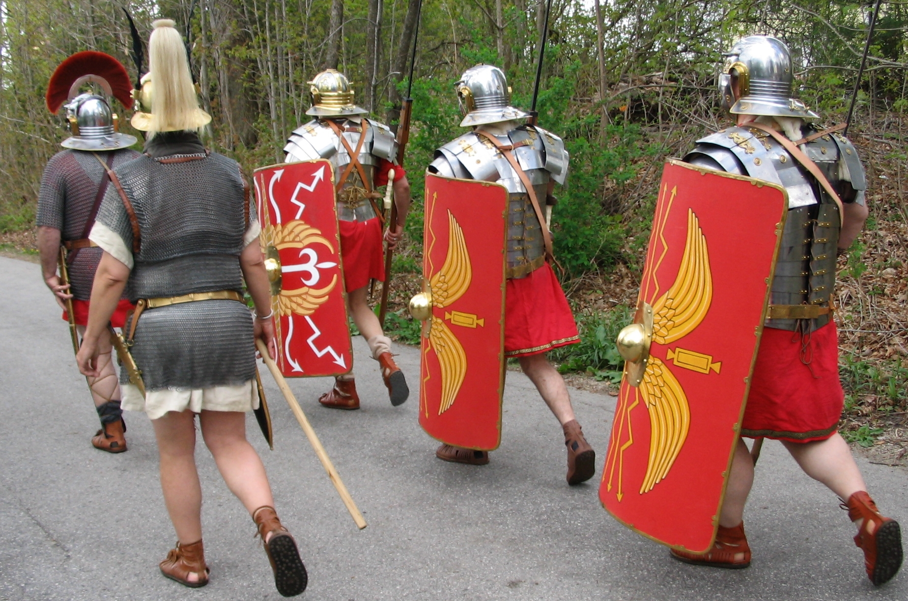 Roman reenactors dressed as 2nd-century legionaries on the march carrying shields and javelins